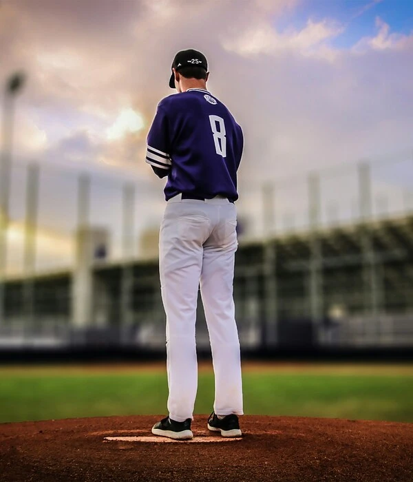 player wearing custom navy blue and white color baseball uniform designed by Humex Apparel
